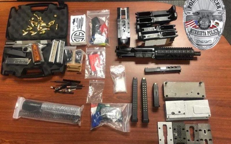 Two gang members arrested as they stand in a garage with guns