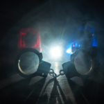 handcuffs and police lights - stock image
